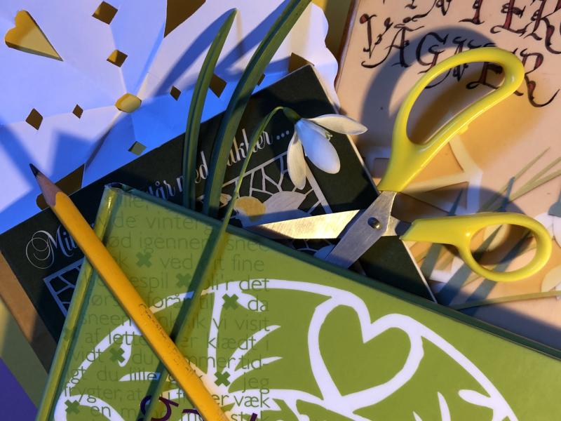 Gækkebrev, saks, pen og bøger med gækkevers