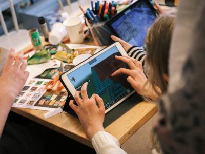 Fotografi af børn der spiller på iPad og klippe-klistrer