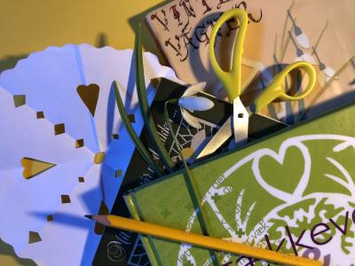 Gækkebrev, saks, pen og bøger med gækkevers