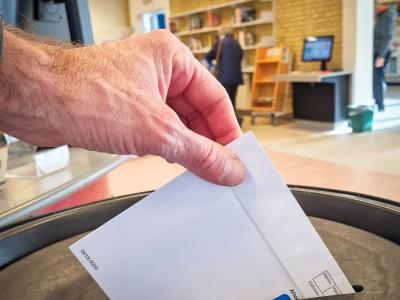 Fotografi af hånd der afleverer stemmeseddel