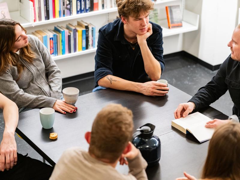 Fotografi af mennesker i samtale om en bog