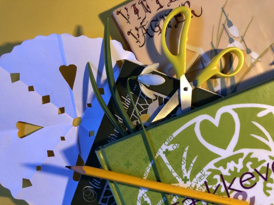 Gækkebrev, saks, pen og bøger med gækkevers