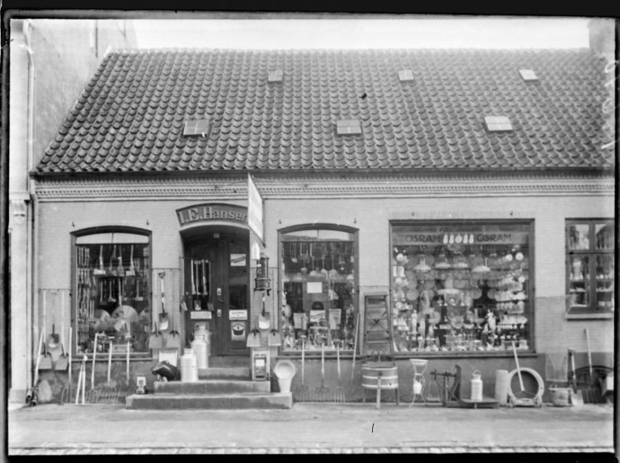 Købmand og Isenkræmmer I.E. Hansen Storgade 38 i Sorø. 1915. Varerne udstillet i butikkens vinduer og på fortovet foran butikken.