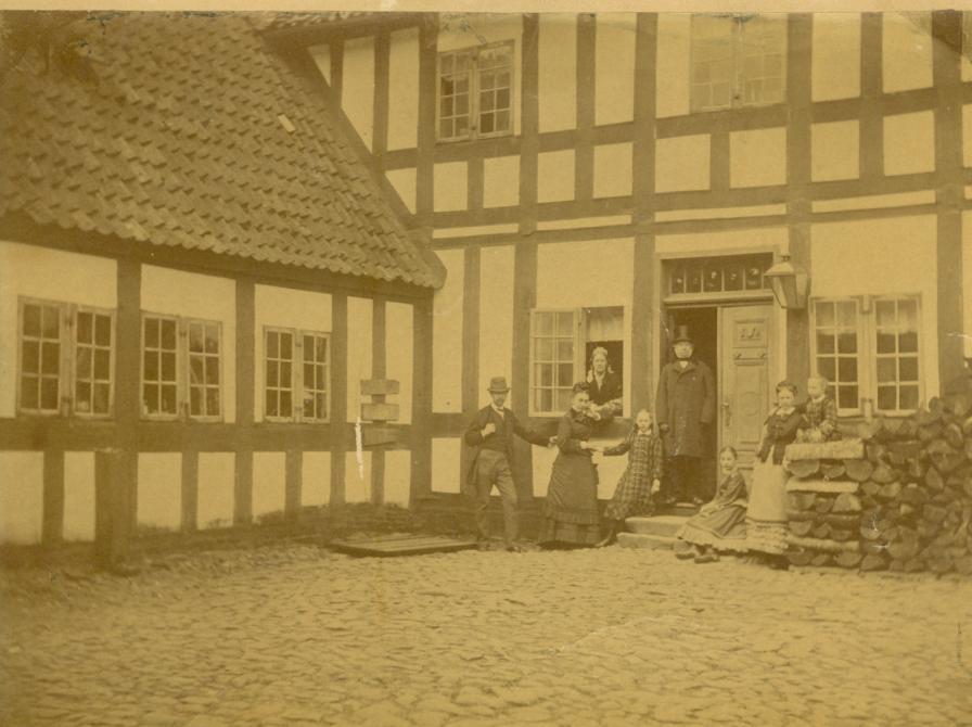 Billede fra apotekergården, Sorø Apotek. I døren står apoteker Glahn med familie ca. 1855