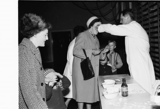 Billederne viser vaccination mod polio med vaccine på en sukkerknald. Året er 1963 og  det er på en skole i Sorø-området.